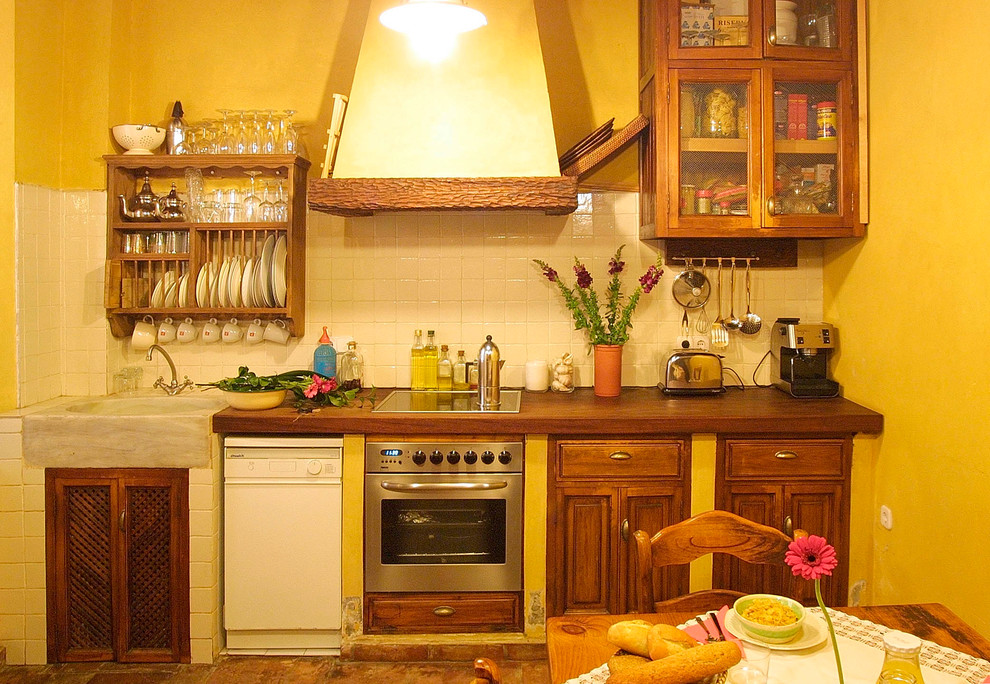 セビリアにある低価格の小さなラスティックスタイルのおしゃれなキッチン (シングルシンク、中間色木目調キャビネット、木材カウンター、アイランドなし) の写真