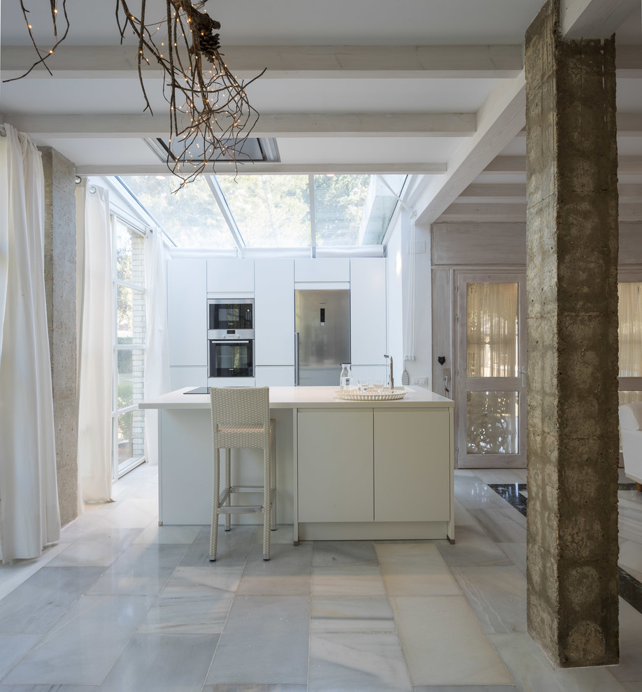 Esempio di una cucina contemporanea con ante lisce, ante bianche, elettrodomestici in acciaio inossidabile, pavimento in marmo, pavimento bianco, top bianco e lavello sottopiano
