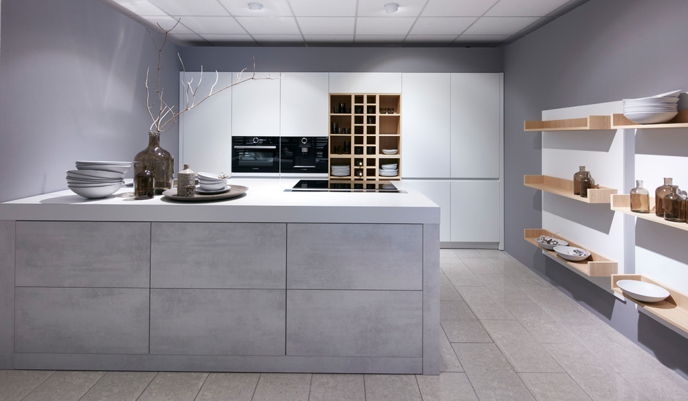 Immagine di una grande cucina industriale con lavello stile country, ante bianche, elettrodomestici neri, pavimento con piastrelle in ceramica, pavimento grigio e top bianco