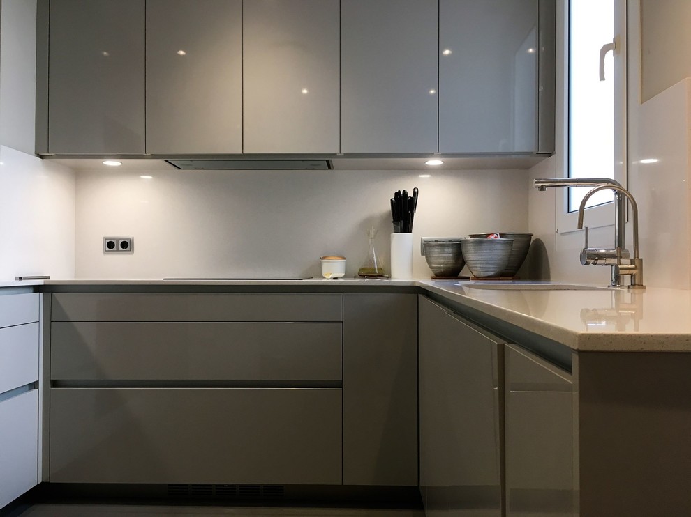 Mid-sized trendy u-shaped concrete floor and gray floor eat-in kitchen photo in Barcelona with flat-panel cabinets, gray cabinets, quartz countertops and no island