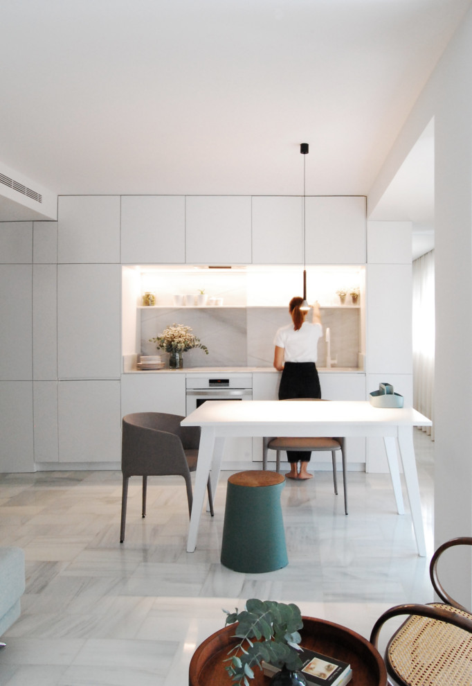 Idéer för ett litet modernt grå linjärt kök med öppen planlösning, med släta luckor, vita skåp, marmorbänkskiva, grått stänkskydd, stänkskydd i marmor, vita vitvaror, marmorgolv och grått golv