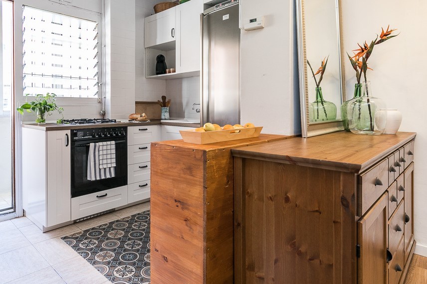 Small traditional l-shaped open plan kitchen in Barcelona with a single-bowl sink, white cabinets, laminate countertops, white splashback, ceramic splashback, coloured appliances, ceramic flooring, a breakfast bar, beige floors and brown worktops.