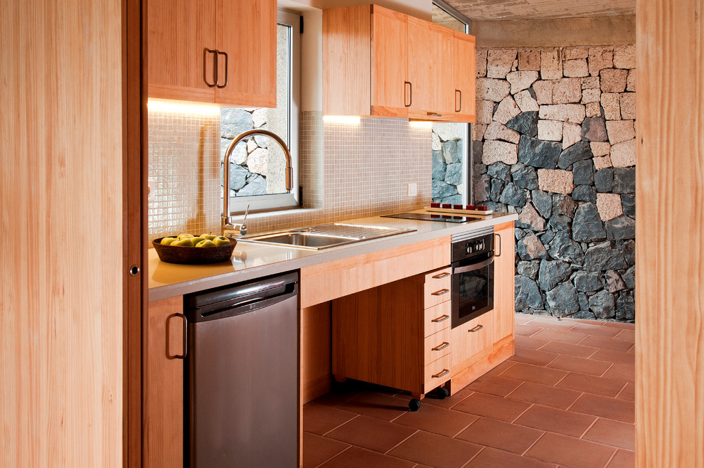 Example of a mid-sized trendy u-shaped terra-cotta tile enclosed kitchen design in Other with a single-bowl sink, flat-panel cabinets, medium tone wood cabinets, solid surface countertops, beige backsplash, ceramic backsplash, stainless steel appliances and no island