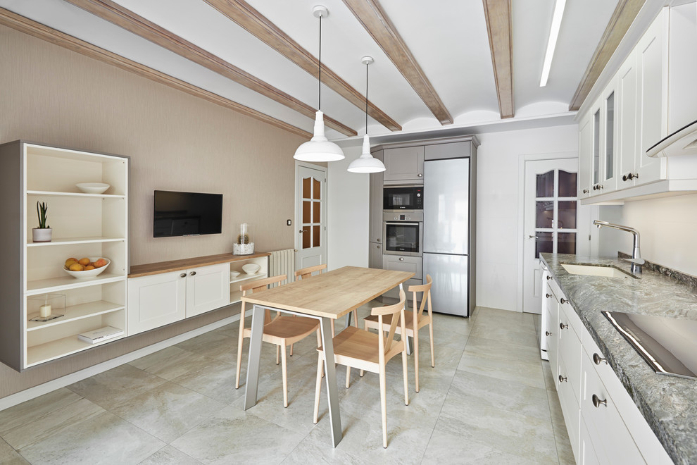 Immagine di una cucina tradizionale di medie dimensioni con lavello sottopiano, ante lisce, paraspruzzi bianco, elettrodomestici in acciaio inossidabile, nessuna isola, ante beige, top in granito, pavimento in gres porcellanato e pavimento beige