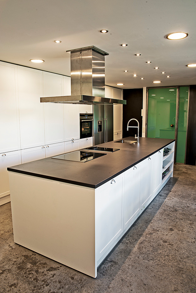 Imagen de cocina lineal minimalista de tamaño medio abierta con una isla, suelo gris y encimera de granito