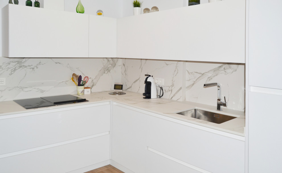 Inspiration for a small contemporary l-shaped kitchen with flat-panel cabinets, white cabinets, engineered stone countertops, white splashback, ceramic flooring and white worktops.