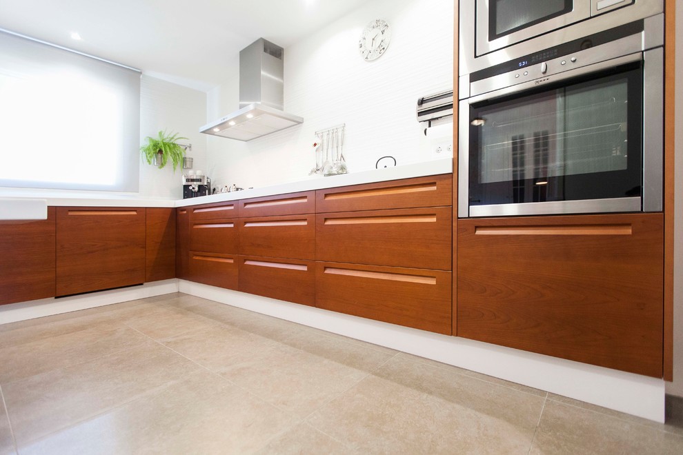 Foto på ett mellanstort funkis kök, med en integrerad diskho, släta luckor, vita skåp, rostfria vitvaror, klinkergolv i porslin och brunt golv