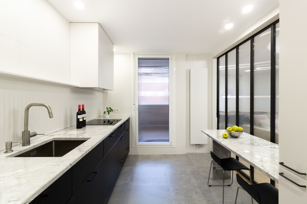 This is an example of a medium sized scandi single-wall open plan kitchen in Madrid with a submerged sink, flat-panel cabinets, black cabinets, white splashback, no island, grey floors, white worktops, quartz worktops, ceramic splashback, integrated appliances and ceramic flooring.