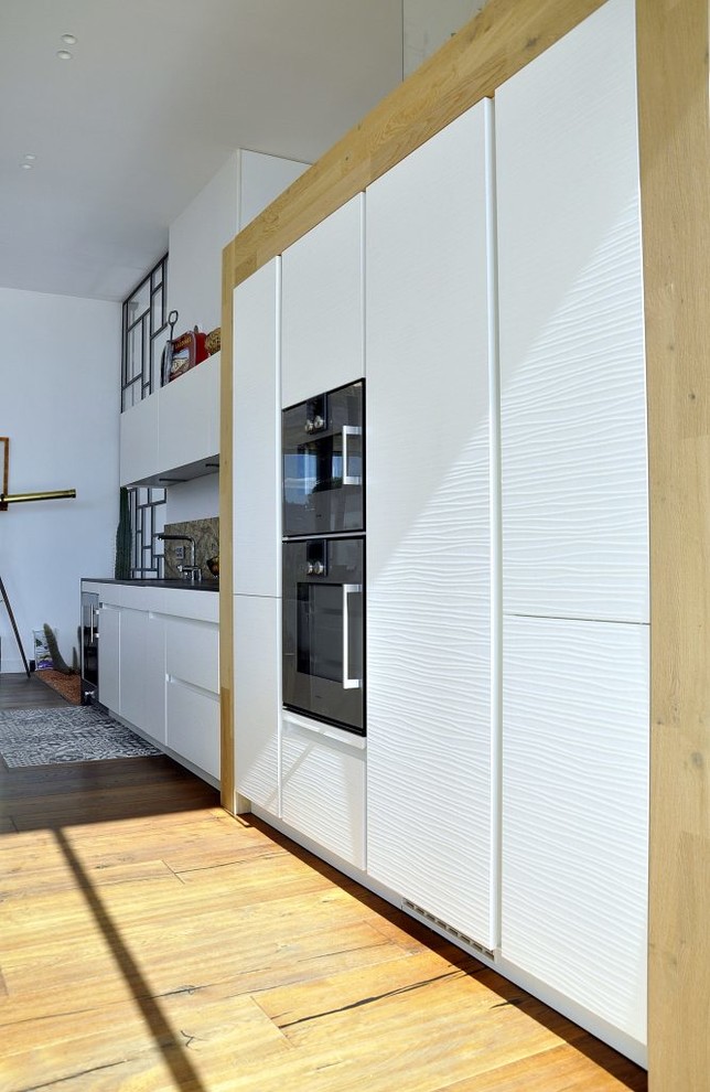 Exempel på ett mellanstort modernt linjärt kök med öppen planlösning, med luckor med upphöjd panel, vita skåp, bänkskiva i kvarts, rostfria vitvaror, mellanmörkt trägolv, en köksö och brunt golv