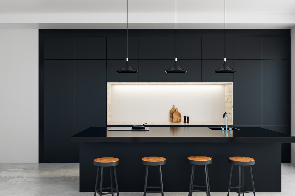 Exemple d'une cuisine ouverte parallèle tendance avec plan de travail noir, un évier intégré, un placard à porte plane, des portes de placard noires, un électroménager noir, sol en béton ciré, îlot et un sol gris.
