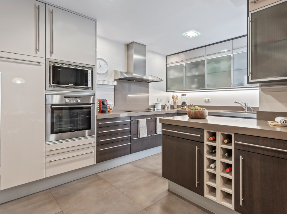 Foto di una cucina abitabile minimal con ante lisce, elettrodomestici in acciaio inossidabile e penisola