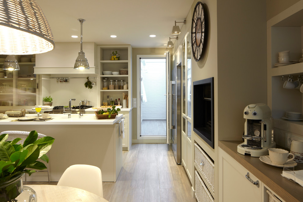 バルセロナにある高級な広いコンテンポラリースタイルのおしゃれなキッチン (シングルシンク、レイズドパネル扉のキャビネット、白いキャビネット、シルバーの調理設備、無垢フローリング) の写真