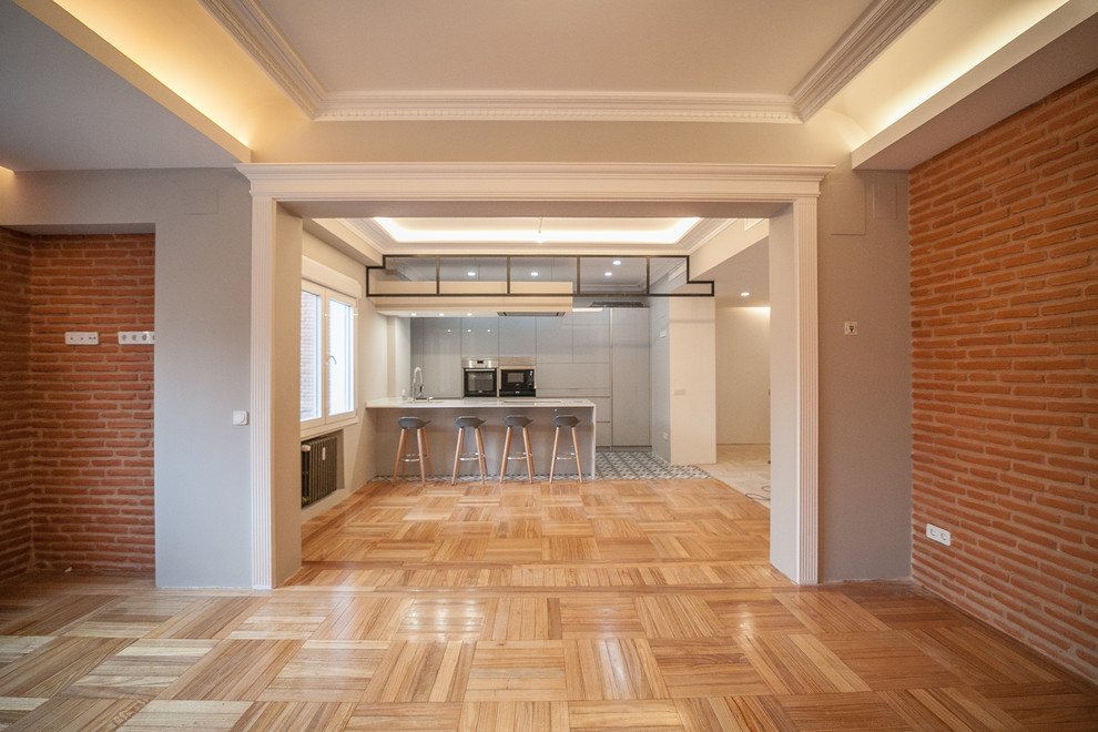 Example of a large minimalist single-wall ceramic tile and multicolored floor kitchen design in Madrid with a double-bowl sink, gray cabinets, metallic backsplash, stainless steel appliances, an island and white countertops