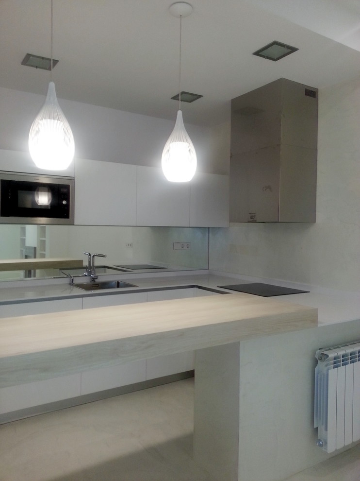 This is an example of a small modern u-shaped open plan kitchen in Madrid with a single-bowl sink, flat-panel cabinets, white cabinets, engineered stone countertops, window splashback, stainless steel appliances, ceramic flooring, a breakfast bar and beige floors.
