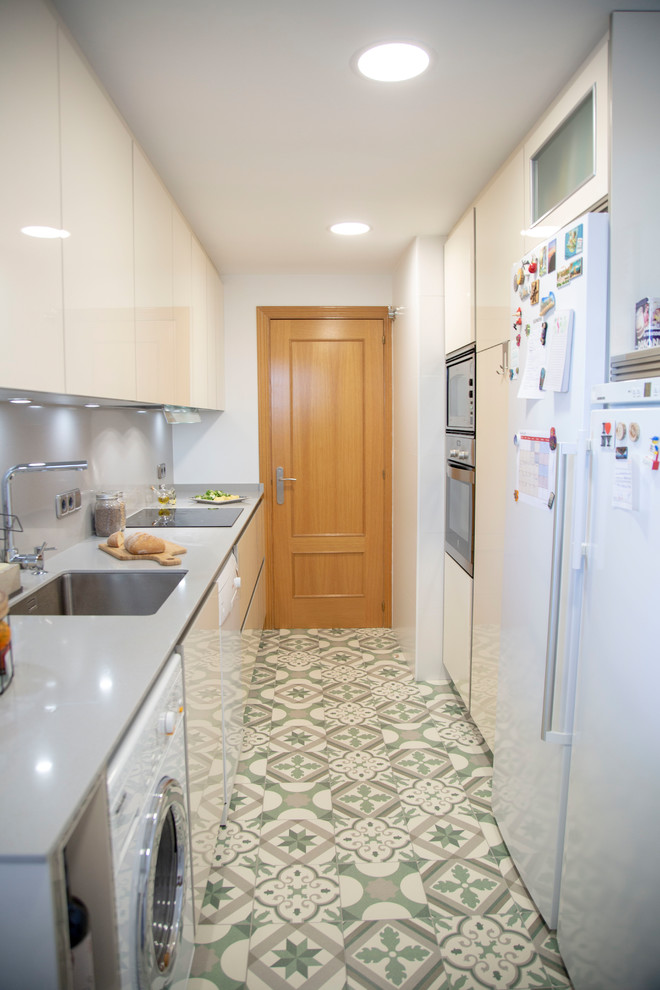 Geschlossene, Einzeilige, Kleine Moderne Küche ohne Insel mit Quarzwerkstein-Arbeitsplatte, Küchenrückwand in Metallic und Küchengeräten aus Edelstahl in Madrid
