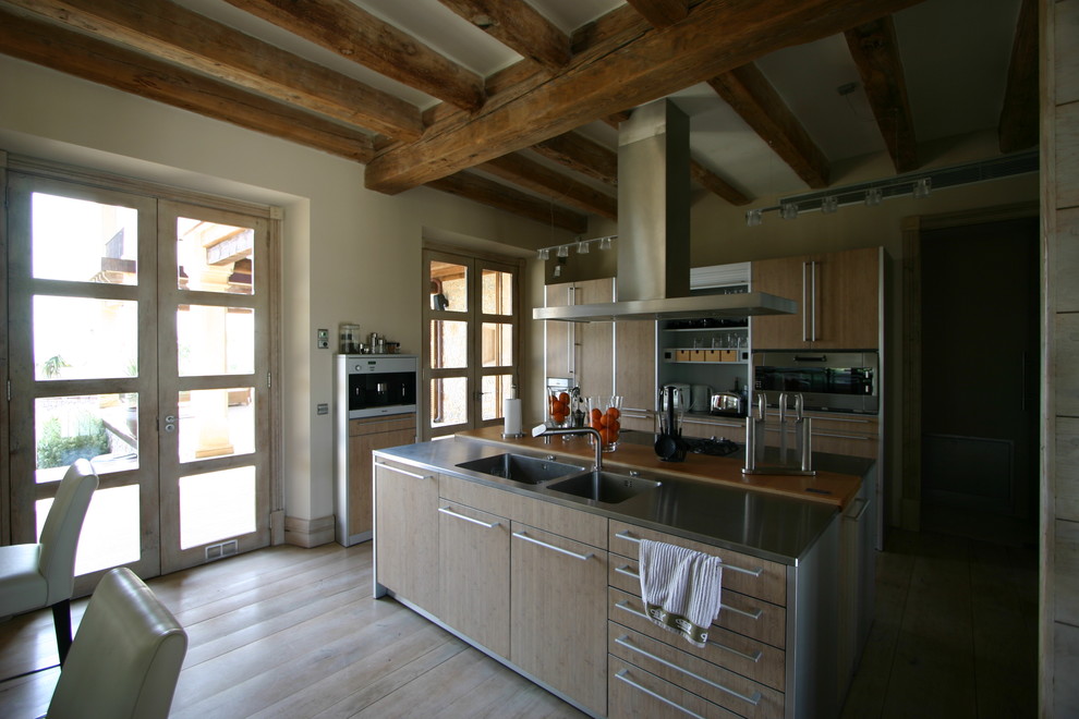 Diseño de cocina lineal rural de tamaño medio abierta con suelo de madera clara, una isla y suelo beige