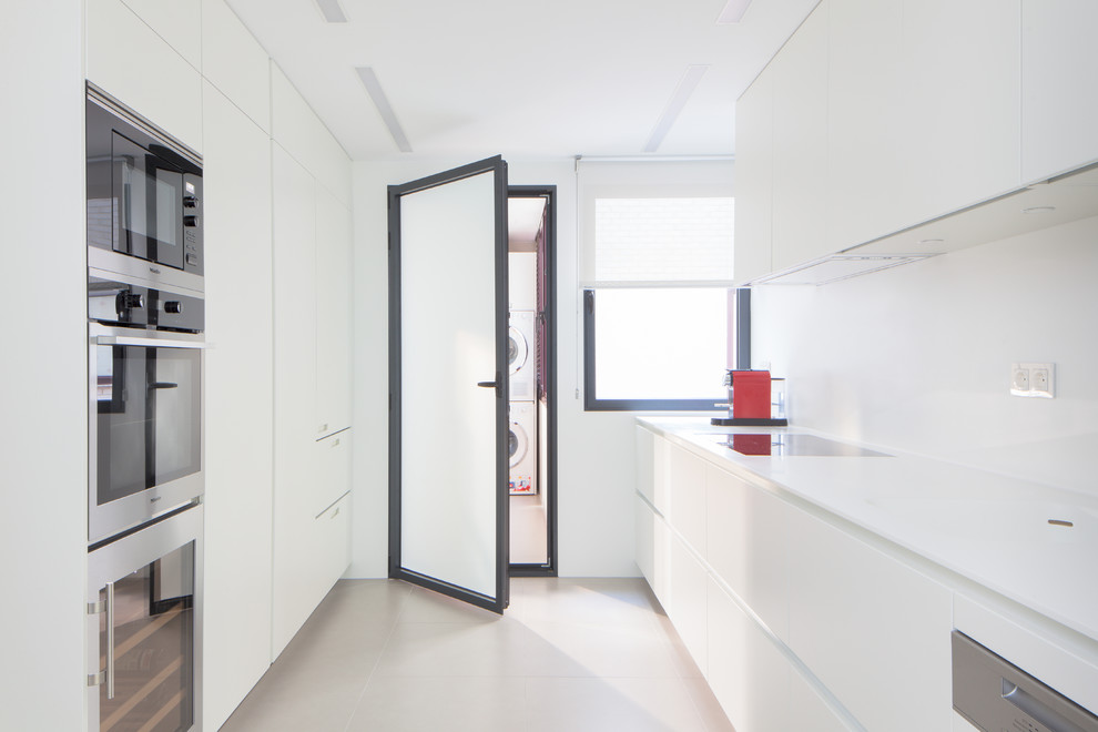 Imagen de cocina lineal minimalista de tamaño medio cerrada sin isla con armarios con paneles lisos y puertas de armario blancas