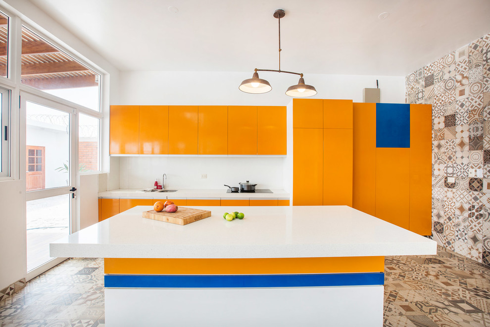 Идея дизайна: параллельная кухня в современном стиле с врезной мойкой, плоскими фасадами, оранжевыми фасадами, белым фартуком, техникой под мебельный фасад, островом, разноцветным полом и белой столешницей