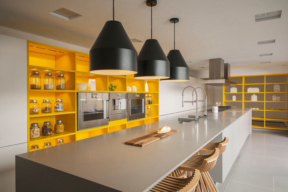 На фото: большая прямая кухня в современном стиле с открытыми фасадами, желтыми фасадами, островом, серым полом и техникой из нержавеющей стали с