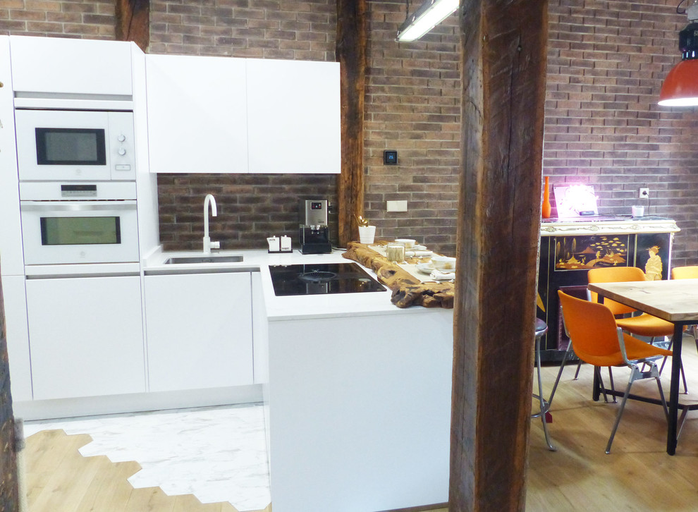 На фото: угловая кухня-гостиная среднего размера в стиле неоклассика (современная классика) с белыми фасадами, столешницей из кварцевого агломерата, полуостровом и белой столешницей с