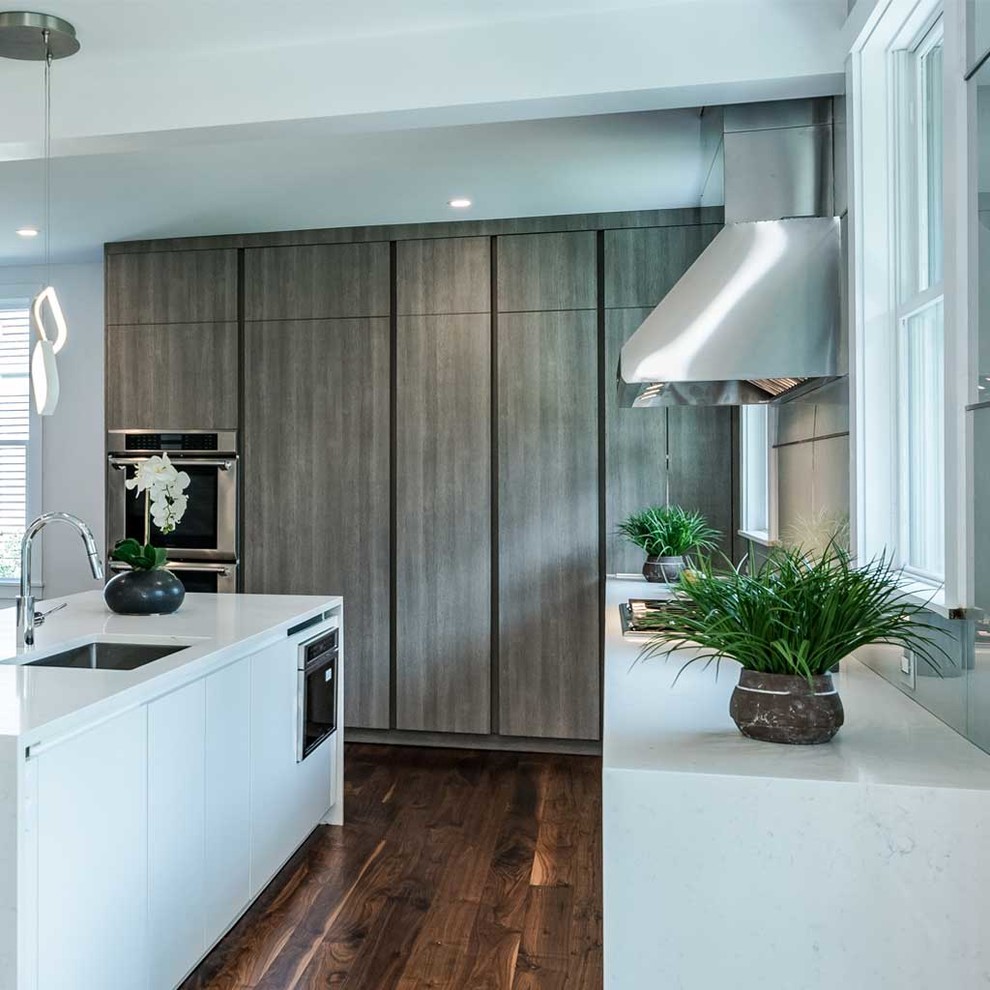 This is an example of a medium sized contemporary single-wall open plan kitchen in Boston with flat-panel cabinets, medium wood cabinets, engineered stone countertops, stainless steel appliances, dark hardwood flooring, an island and brown floors.
