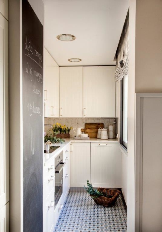 Modelo de cocinas en L rústica pequeña cerrada sin isla con armarios con paneles empotrados y puertas de armario blancas