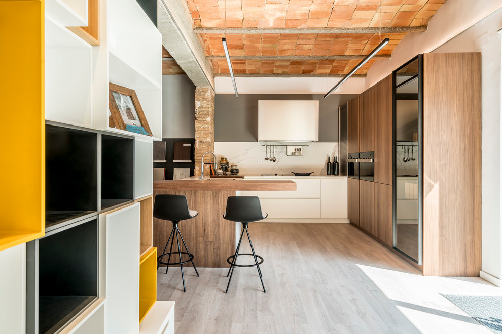 Imagen de cocinas en L industrial de tamaño medio abierta con armarios con paneles lisos, puertas de armario blancas y península