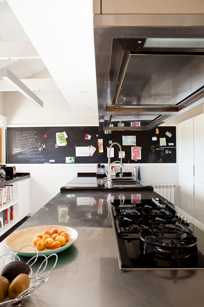 Foto de cocina comedor contemporánea grande con fregadero de doble seno, encimera de acero inoxidable, electrodomésticos de acero inoxidable y una isla