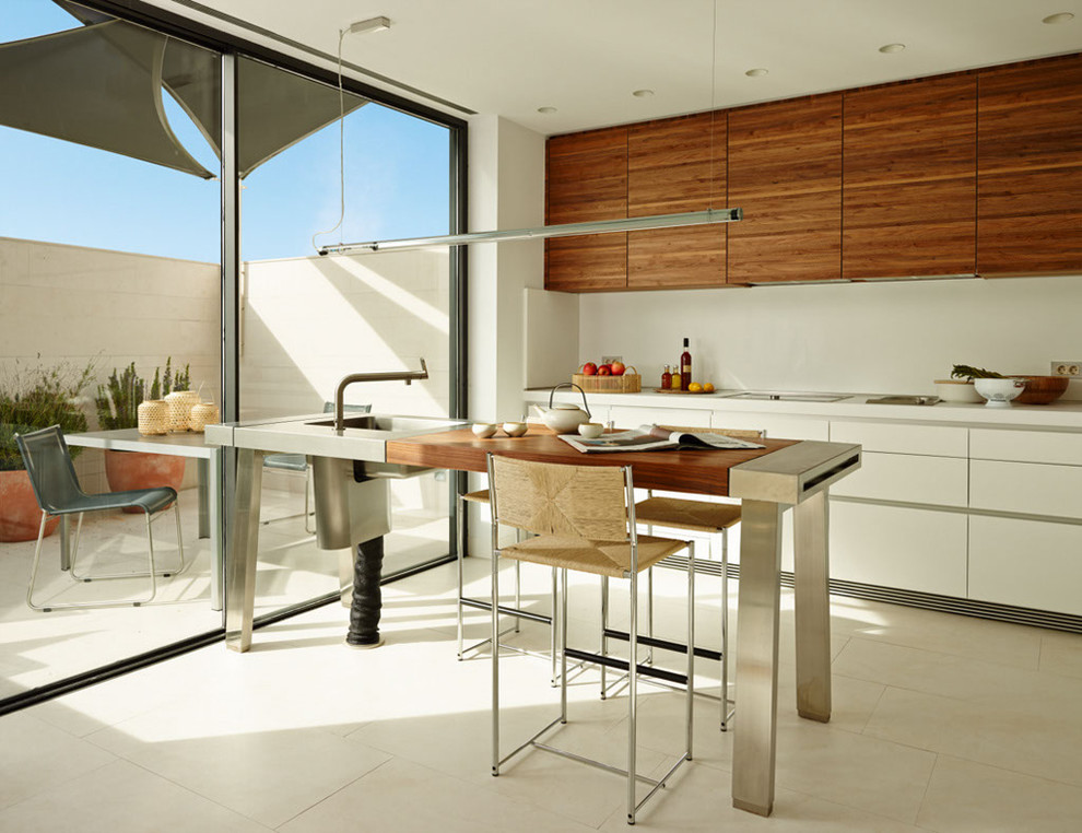 На фото: прямая кухня среднего размера в современном стиле с обеденным столом, монолитной мойкой, плоскими фасадами, белыми фасадами, белым фартуком, полом из керамической плитки и полуостровом