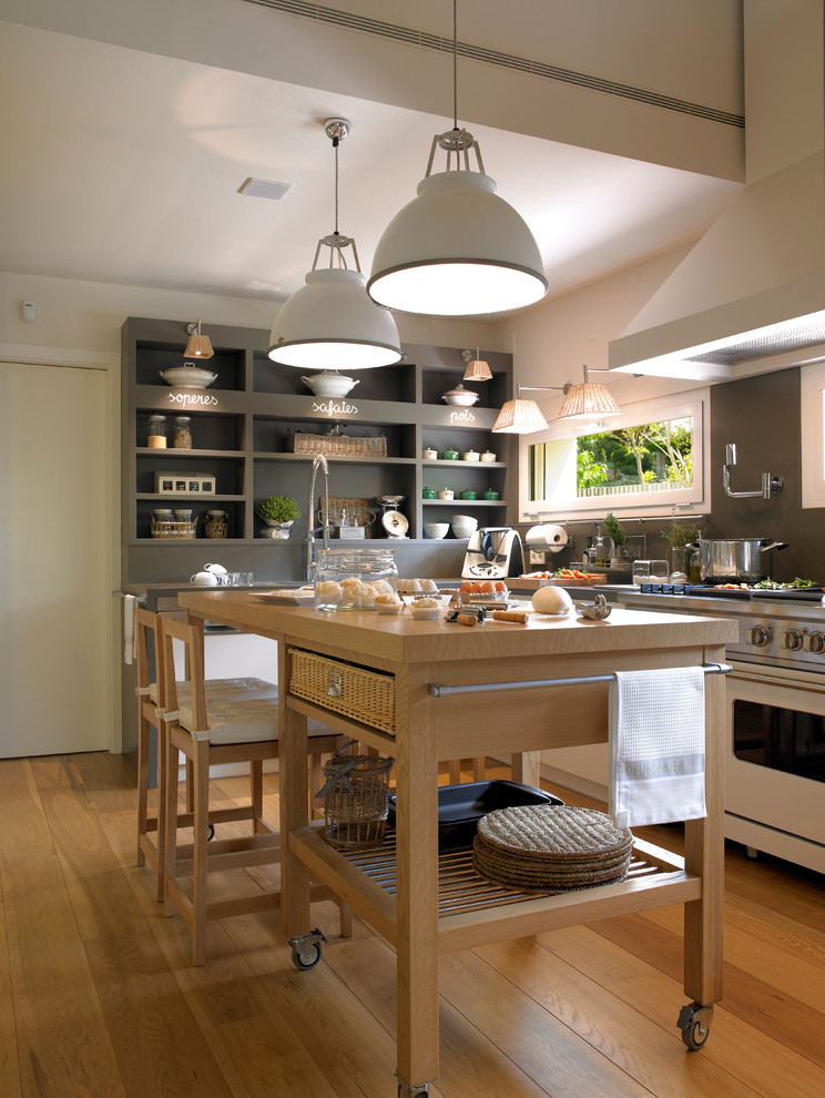 Diseño de cocina comedor lineal actual de tamaño medio con suelo de madera en tonos medios y una isla