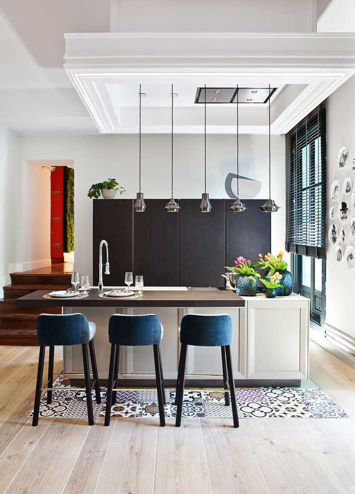 Пример оригинального дизайна: параллельная кухня-гостиная в современном стиле с плоскими фасадами, черными фасадами, деревянной столешницей, светлым паркетным полом, островом и красивой плиткой