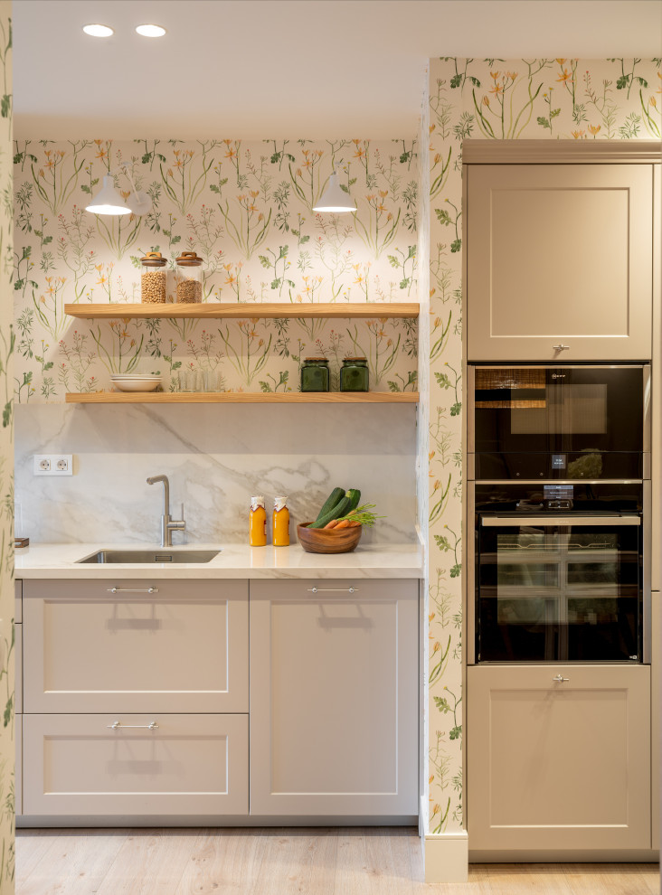 Idéer för att renovera ett mellanstort vintage vit linjärt vitt kök och matrum, med en undermonterad diskho, luckor med upphöjd panel, grå skåp, bänkskiva i kvarts, vitt stänkskydd, rostfria vitvaror, laminatgolv och brunt golv