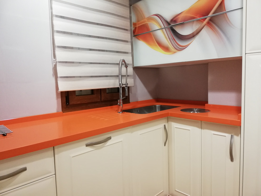Idéer för små vintage oranget kök, med en undermonterad diskho, luckor med profilerade fronter, vita skåp, bänkskiva i kvarts, rostfria vitvaror, terrazzogolv, en halv köksö och flerfärgat golv