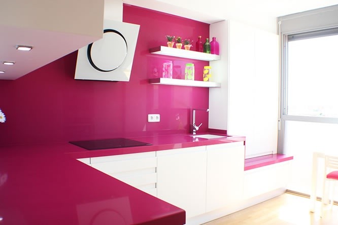 На фото: кухня в стиле модернизм с врезной мойкой, столешницей из кварцевого агломерата, розовым фартуком, фартуком из каменной плиты, белой техникой и светлым паркетным полом с