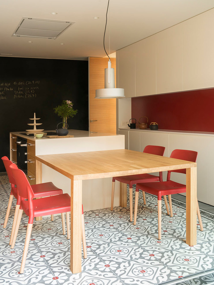 Réalisation d'une grande cuisine linéaire design en bois brun fermée avec un placard à porte shaker, un sol en carrelage de céramique, îlot, un sol multicolore et une crédence rouge.