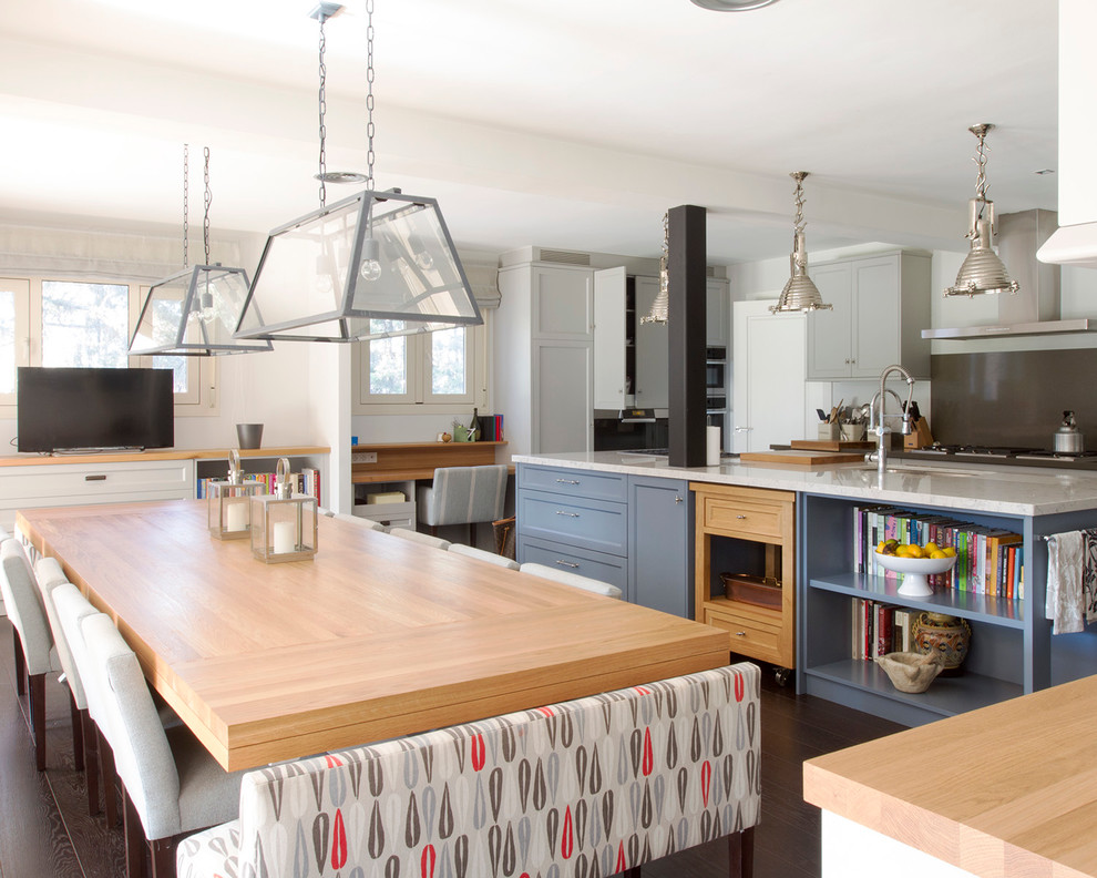This is an example of a large bohemian galley kitchen/diner in Madrid with a submerged sink, recessed-panel cabinets, blue cabinets, quartz worktops, stainless steel appliances, dark hardwood flooring and an island.