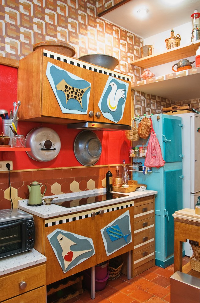 Cette photo montre une cuisine éclectique en bois brun avec une crédence multicolore, tomettes au sol et un électroménager de couleur.