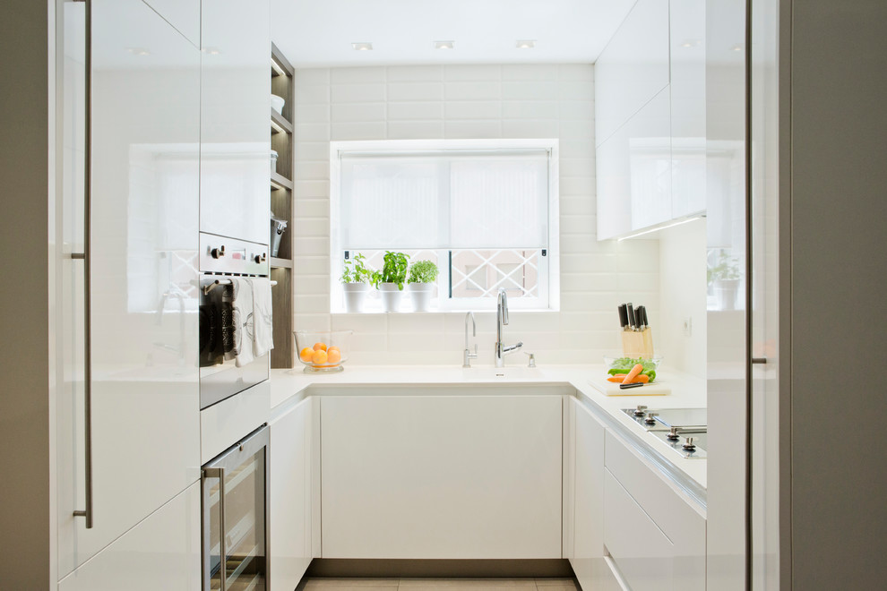 Geschlossene, Kleine Klassische Küche ohne Insel in U-Form mit flächenbündigen Schrankfronten, weißen Schränken und Küchenrückwand in Weiß in Barcelona