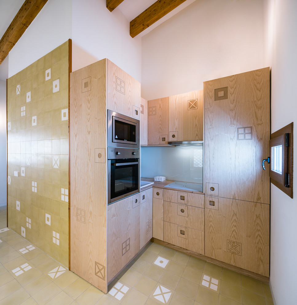 Imagen de cocinas en L de estilo de casa de campo pequeña con armarios con paneles lisos, puertas de armario de madera clara, encimera de madera y electrodomésticos de acero inoxidable