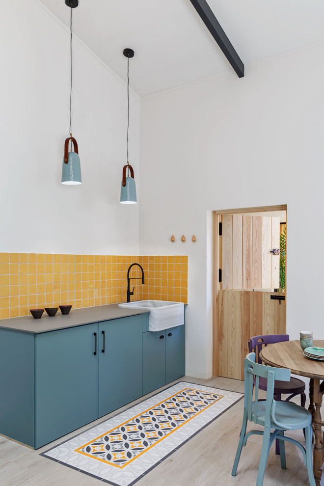 Foto på ett mellanstort minimalistiskt grå linjärt kök, med en nedsänkt diskho, släta luckor, turkosa skåp, bänkskiva i kvarts, klinkergolv i porslin, beiget golv, gult stänkskydd och integrerade vitvaror