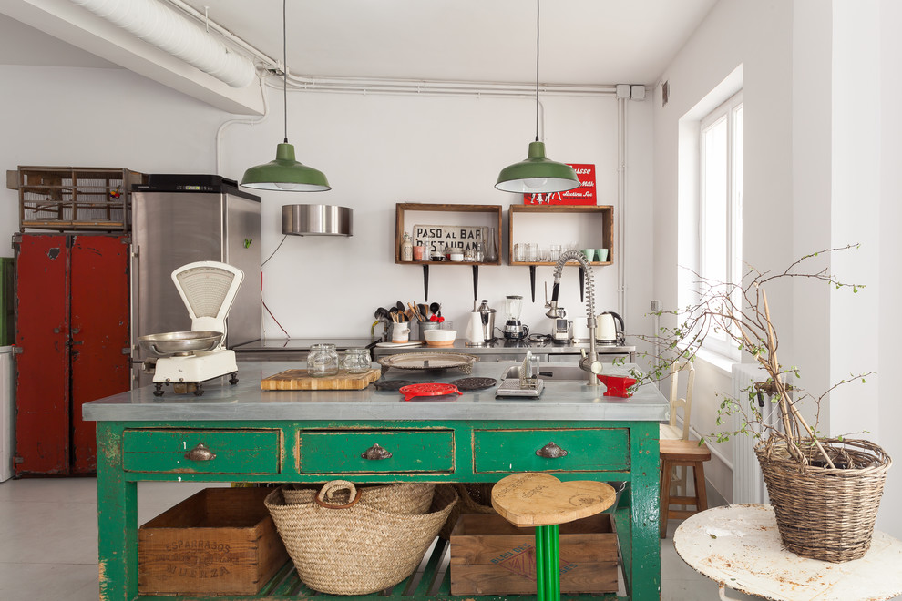 マドリードにあるエクレクティックスタイルのおしゃれなキッチン (ドロップインシンク、フラットパネル扉のキャビネット、緑のキャビネット、白いキッチンパネル、シルバーの調理設備、グレーの床、グレーのキッチンカウンター) の写真