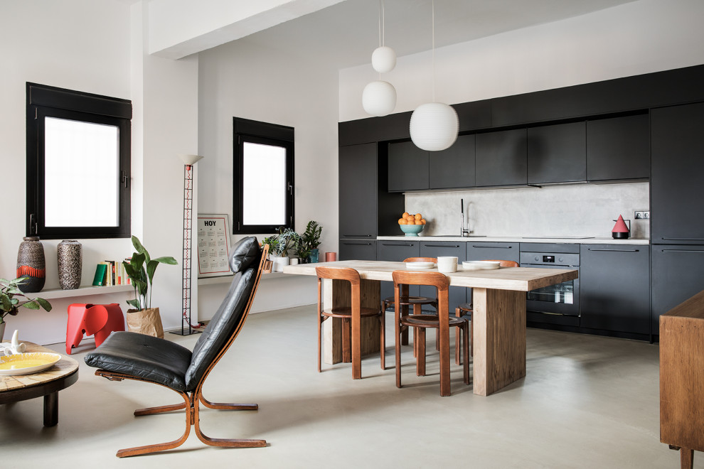 Immagine di una cucina nordica con ante lisce, ante nere, paraspruzzi grigio, elettrodomestici neri, pavimento in cemento, pavimento grigio e top grigio