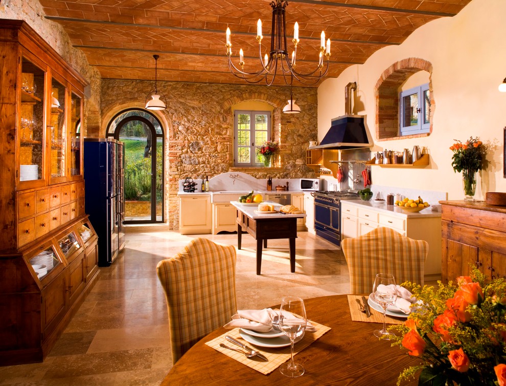 マヨルカ島にある地中海スタイルのおしゃれなキッチン (シェーカースタイル扉のキャビネット、黄色いキャビネット、カラー調理設備、ベージュの床) の写真