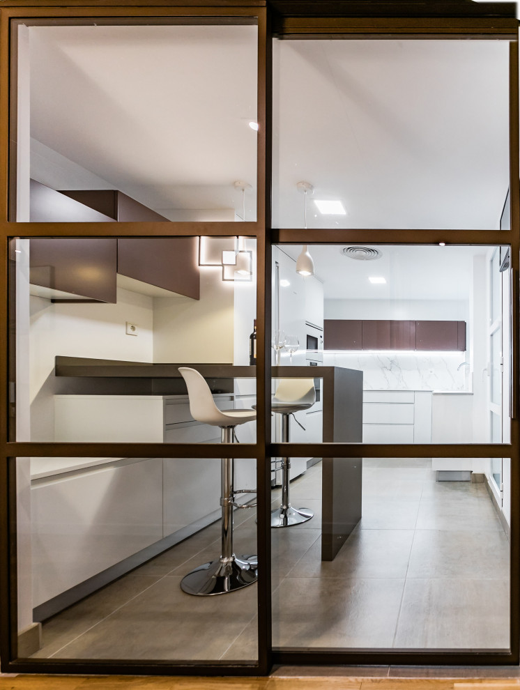 Photo of a medium sized contemporary l-shaped enclosed kitchen in Valencia with flat-panel cabinets, white appliances and a breakfast bar.