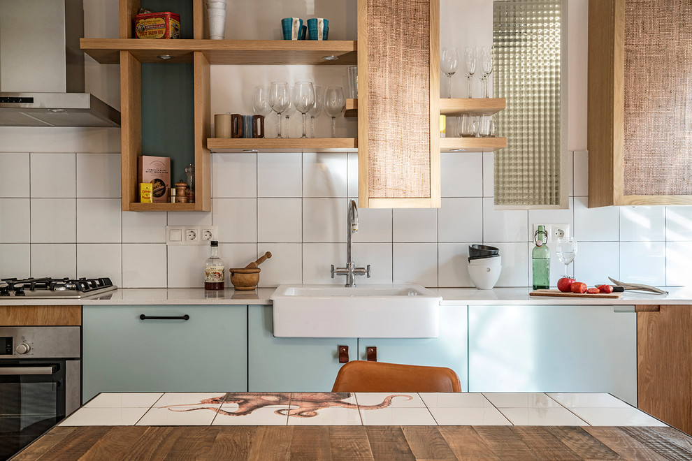 Inspiration for a small mediterranean single-wall concrete floor eat-in kitchen remodel in Barcelona with a single-bowl sink, open cabinets, blue cabinets, quartz countertops, white backsplash, ceramic backsplash, stainless steel appliances and no island