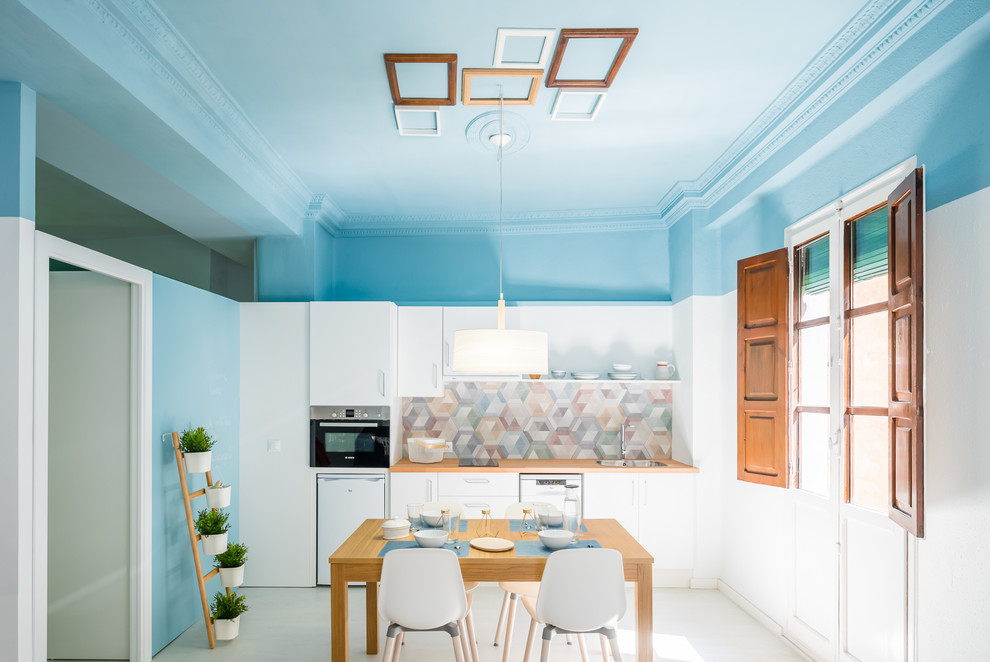 Design ideas for a medium sized nautical single-wall kitchen/diner in Valencia with flat-panel cabinets, white cabinets, wood worktops, multi-coloured splashback, no island, white floors and brown worktops.