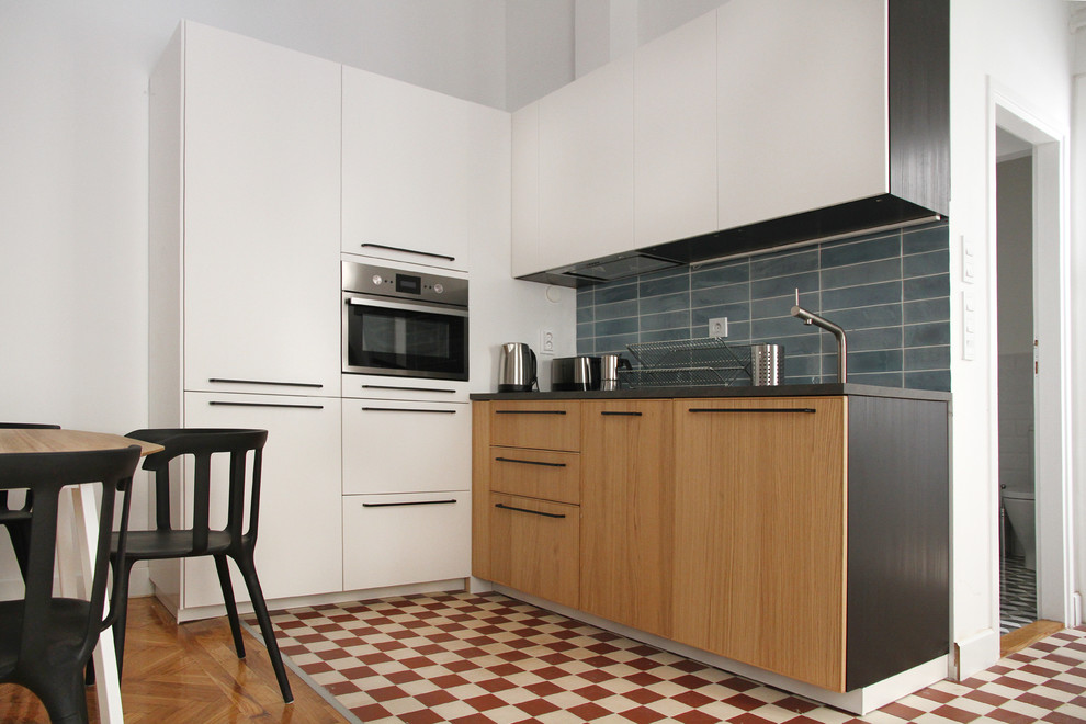 Inspiration for a small contemporary l-shaped cement tile floor and red floor open concept kitchen remodel in Madrid with a single-bowl sink, flat-panel cabinets, medium tone wood cabinets, blue backsplash, ceramic backsplash and paneled appliances