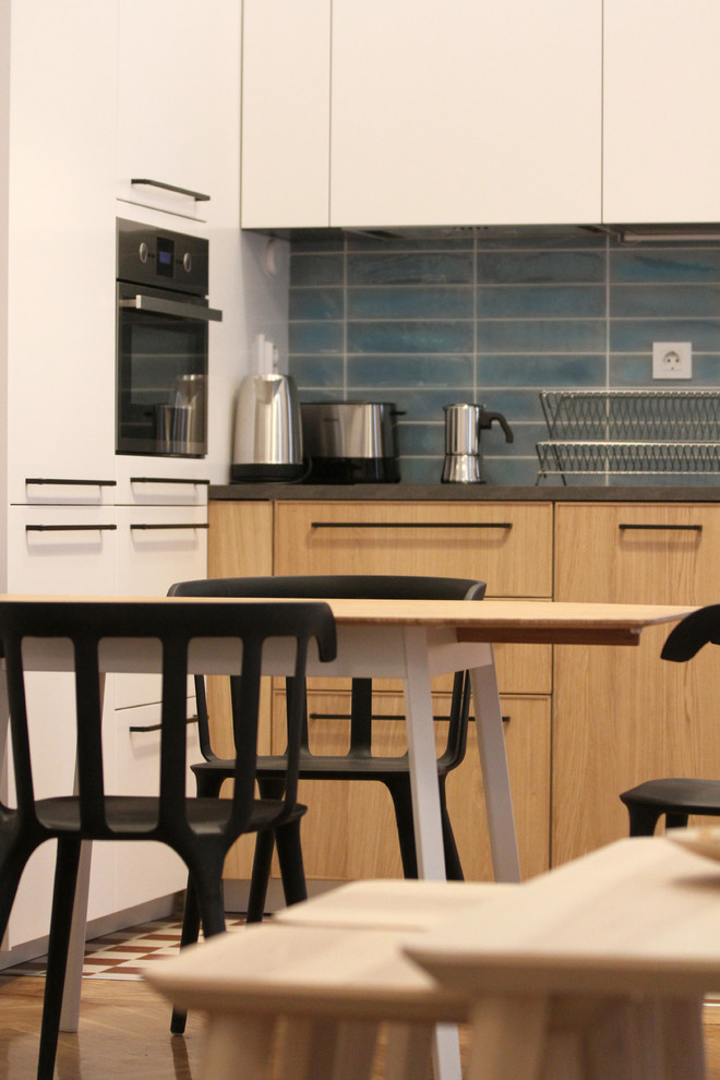Exemple d'une petite cuisine ouverte tendance en L et bois brun avec un évier posé, un placard à porte plane, une crédence bleue, une crédence en céramique, un électroménager en acier inoxydable, carreaux de ciment au sol et un sol rouge.