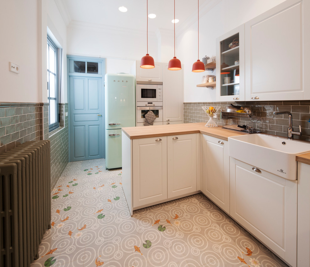 Mid-sized danish u-shaped ceramic tile enclosed kitchen photo in Other with a single-bowl sink, recessed-panel cabinets, white cabinets, wood countertops and a peninsula