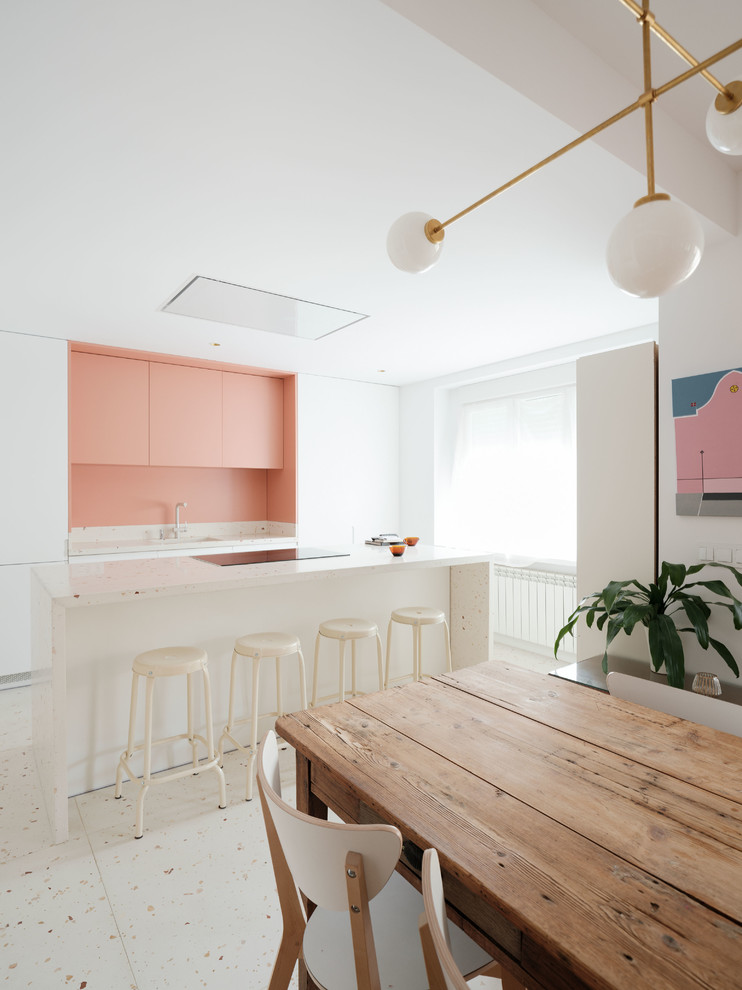 Идея дизайна: параллельная кухня в современном стиле с обеденным столом, плоскими фасадами, белыми фасадами, розовым фартуком, островом, белым полом, белой столешницей и двухцветным гарнитуром